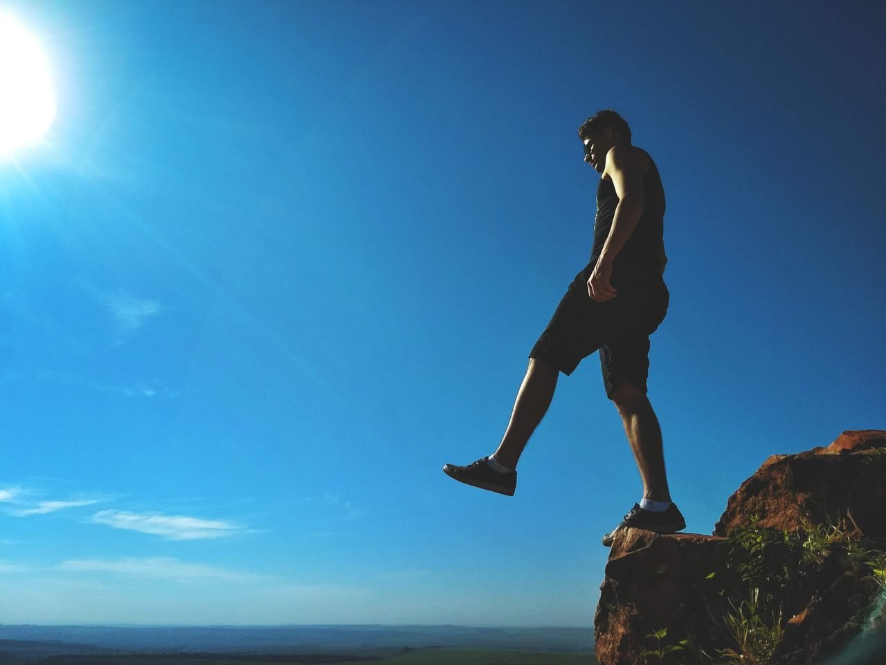 Man standing on a clif and thinking about starting over.